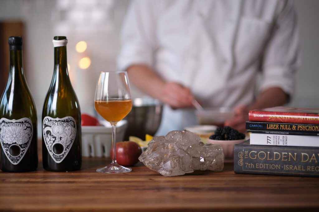 chef in background with wine bottles, crystal, books